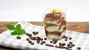 Tiramisu – vrstevnatý dezert z mascarpone, piškotů namočených v kávě a kakaovým posypem ve skleničce