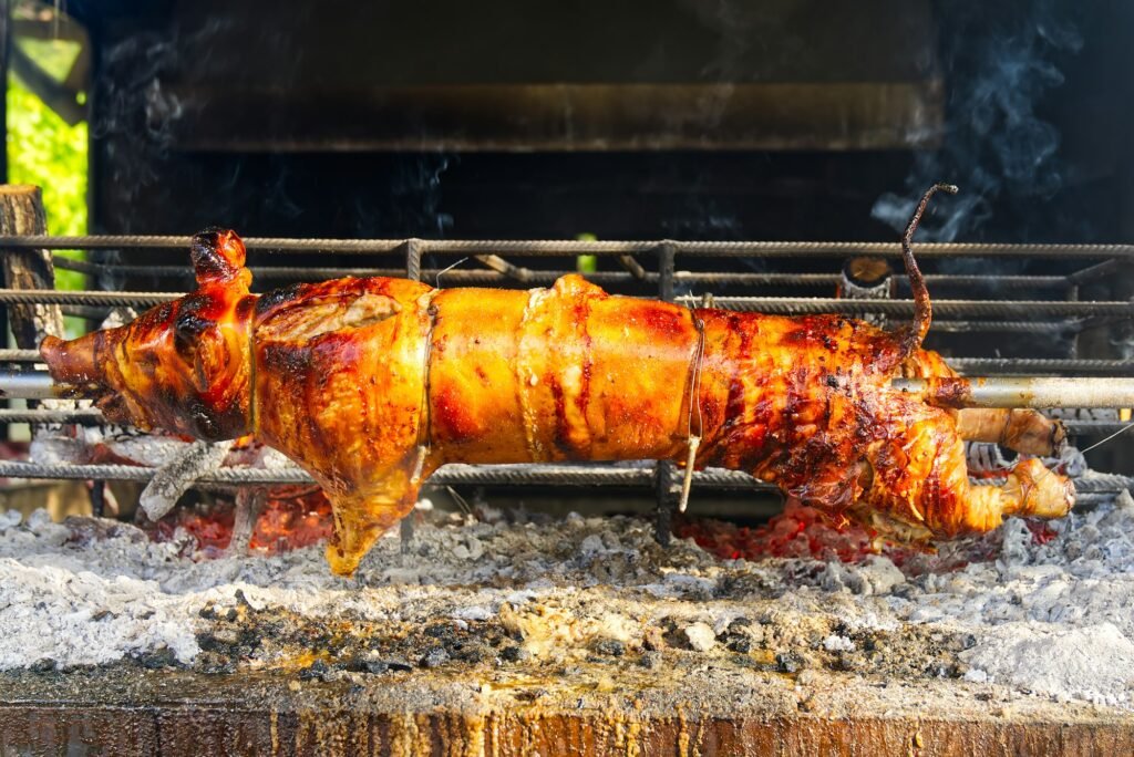 Celé prase na rožni. Prase pečené na grilovací rožni. Venkovní gril v otevřeném grilu. Grill Catering