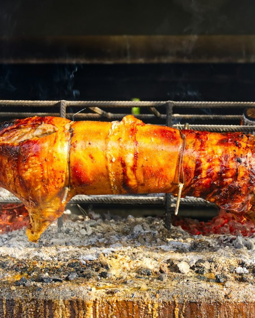 Celé prase na rožni. Prase pečené na grilovací rožni. Venkovní gril v otevřeném grilu. Grill Catering